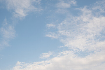 Clear sky with scattered white clouds. The clouds vary in size and shape, creating a serene atmosphere. Background light blue