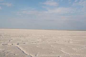 Landscape of a salt lake with a flat white surface under the light of a blue sky. Lake Baskunchak...