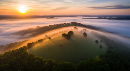 Aerial view of a misty landscape at sunrise with trees and hills