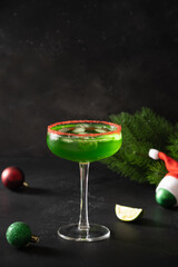 Xmas Green Punch in glass decorated sugar rim on black table make of cool lime sherbet. Tasty drink for Christmas holiday. Rim your festive beverages in red sugar.