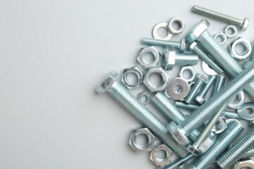 Metal bolts and nuts on white background, flat lay. Space for text
