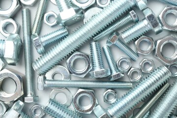 Metal bolts and nuts on white background, flat lay