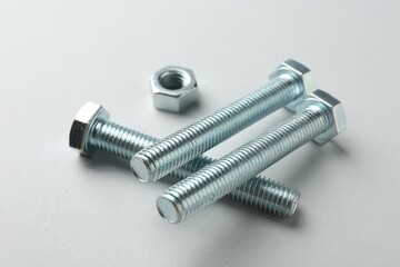 Metal bolts and nut on white background, closeup. Hardware tool