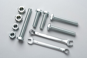 Metal wrenches, nuts and bolts on white background, flat lay