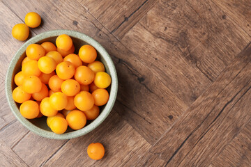 Ripe yellow cherry plums on wooden table, top view. Space for text