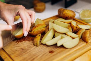 Raw potatoes cut into wedges for baking in the oven as dips