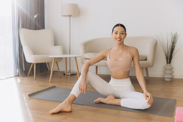 Obraz premium Young Woman Practicing Yoga on a Mat in her Living Room
