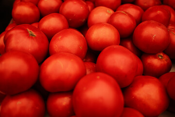 Fresh red tomatoes piled together at a local market. Close-up view of ripe organic vegetables, perfect for cooking, salads, or healthy eating concepts