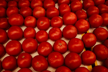 Fresh red tomatoes piled together at a local market. Close-up view of ripe organic vegetables, perfect for cooking, salads, or healthy eating concepts