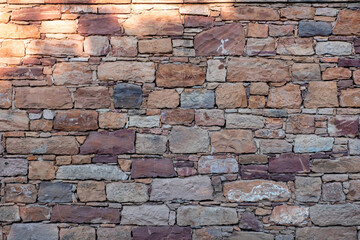 Traditional Kampos stone wall background, Chios Island, Greece. Rectangular blocks in warm red brown colors.