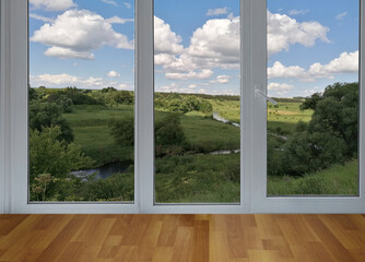 View from the window on the garden green trees and river and fields.