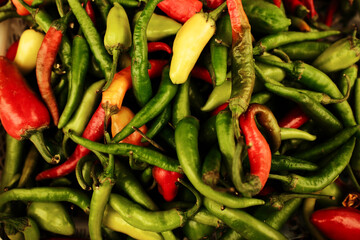 Spicy chili peppers in red, green, and yellow colors at the marketplace. Organic vegetables used for cooking, seasoning, and spicy dishes