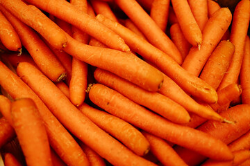 Fresh orange carrots piled at the market. Organic root vegetables rich in vitamins, used in cooking, salads, and healthy diets