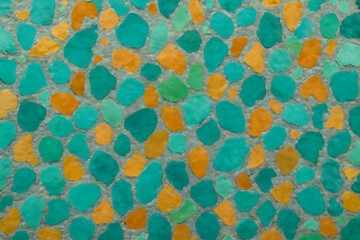 Mosaic of teal and orange pebbles creating a vibrant abstract pattern