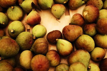 Pile of fresh figs at the market. Ripe seasonal fruit with green and purple skin, organic and sweet