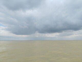 Moody Calm Sea Under a Grey Sky: Wide Shot, Serene Atmosphere, Flat Water Surface