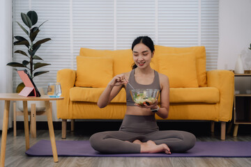 Obraz premium Woman Eating Salad After Yoga at Home