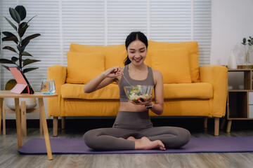 Obraz premium Woman Eating Salad After Yoga at Home