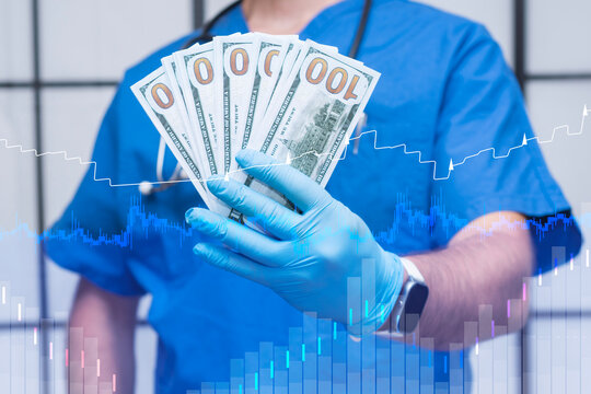Doctor in blue scrubs and gloves holds hundred-dollar bills, with a dynamic financial graph and chart. Concept financial of the healthcare industry, including costs and medical finance.