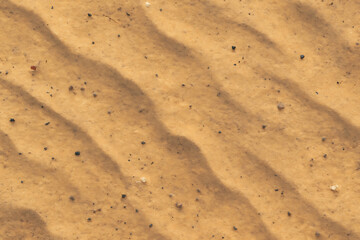 Close up of rippled desert sand with subtle shadows and texture
