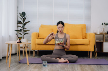 Obraz premium Woman Eating Salad After Yoga at Home
