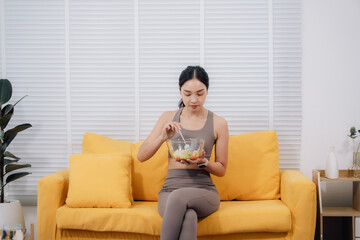 Obraz premium Woman Eating Salad After Online Yoga Class