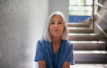Exhausted nurse resting on stairwell during hospital shift