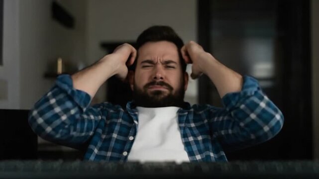 Frustrated man smashing a computer keyboard with his fist, dramatic expression and cinematic lighting, stress and anger at technology 4K video