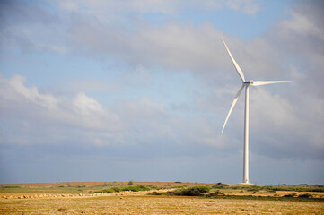 Wind turbine against expansive skies and rugged terrain in Curacao
