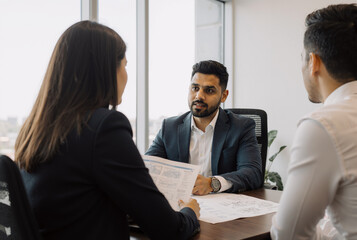 young professionals in a business meeting at modern office discussing documents and strategies
