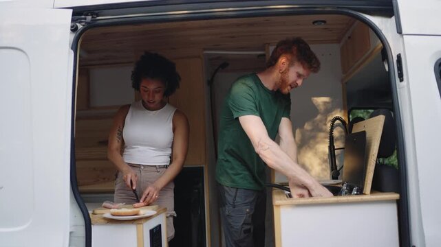 Couple cooking inside their camper van