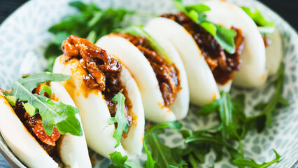 Fluffy steamed bao buns filled with succulent pulled pork, drizzled with smoky barbecue sauce and...