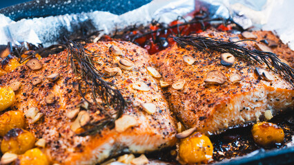 Close-up of perfectly roasted salmon fillet with crispy burnt garlic slices, vibrant cherry tomatoes, and fresh rosemary. A rustic, healthy gourmet meal, ideal for food blogs, recipes, and culinary br