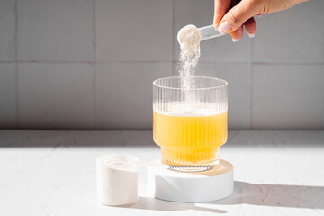 Collagen protein powder in a scoop. Glass of collagen beauty drink. Food supplement.