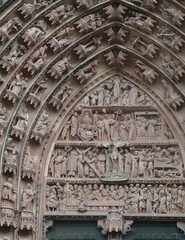 Detailed view of the richly sculpted sandstone portal of Strasbourg Cathedral, showcasing biblical scenes and figures