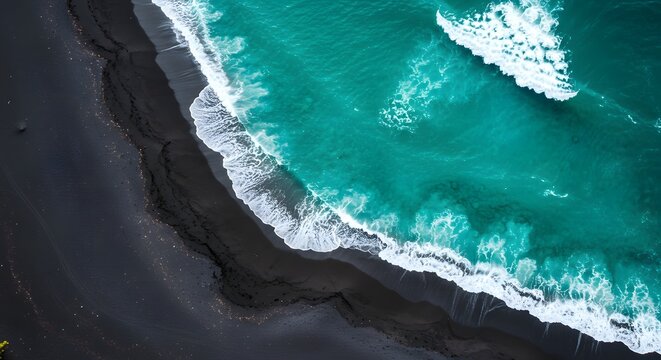 Aerial view of turquoise ocean waves breaking on a dark sand coastline