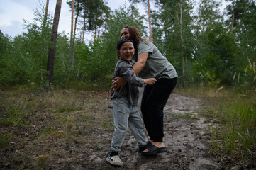 Happy Mother and Son Laughing Together in Forest Nature