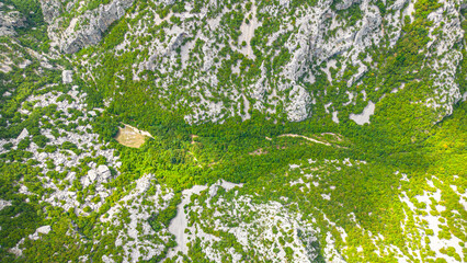 Aerial panoramic view of Paklenica National Park in Croatia with dramatic limestone cliffs, lush green valleys, and the Adriatic Sea in the background. A famous hiking and climbing destination in the 
