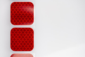 Red Reflective Sticker with Geometric Pattern – Square Safety Marker on White Background, Retroreflective Material for Vehicle or Industrial Use, Close-Up Texture and Design Photography
