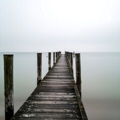Fototapeta premium Tranquil wooden pier on a hazy lake