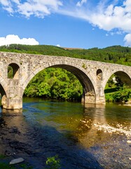 Fototapeta premium Ancient stone arch bridge over a river (1)