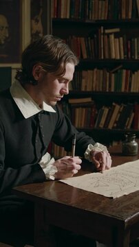 A vintage-style video still of a man writing at a wooden desk, captured from a side angle, surrounded by bookshelves in a dimly lit room.