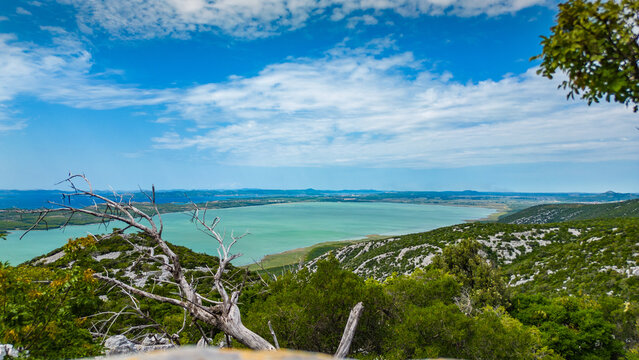 Panoramic view from Vidikovac Kamenjak, the highest point above Vransko Lake Nature Park in Croatia. The viewpoint offers breathtaking views of the Adriatic Sea, surrounding islands, and Dalmatia