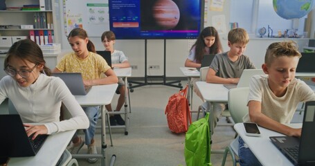 Elementary School Children Using Laptops, Doing Creative Tasks During Digital Art Lesson in Classroom. Digital Screen Showing AI Software for Creating Pictures. Interactive STEM Education. Dolly Shot.