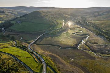 Aerial View of a Scenic Dry Reservoir with Winding Roads and Lush Hills