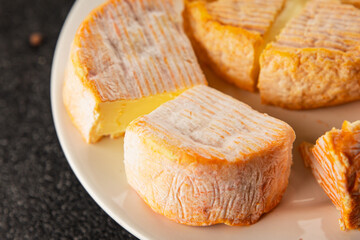 Cheese plate camembert, brie, munster french cheese tasty snack fresh delicious gourmet food background on the table rustic food top view copy space