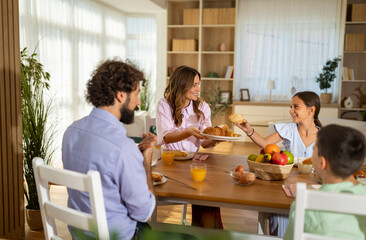 Family shares breakfast in bright home
