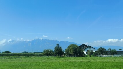 Obraz premium Scenic Landscape with rolling fields, distant mountains, and clear blue sky