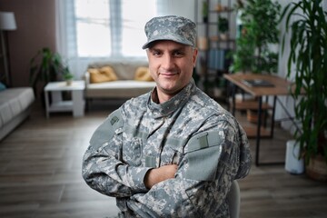 Fototapeta premium Portrait of a smiling soldier sitting at home with arms crossed