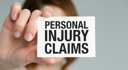 A person is holding a card that says Personal Injury Claims. Concept of responsibility and accountability for any injuries that may occur